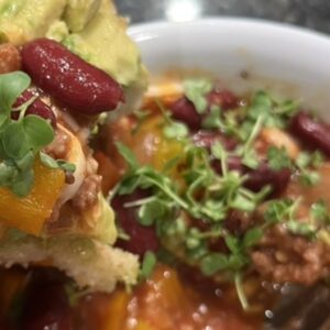 Vegan chili with microgreens in bowl.